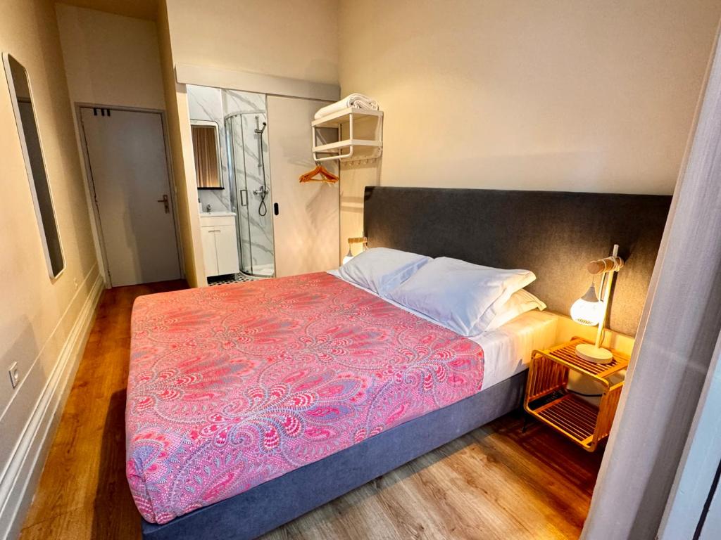 a bedroom with a large bed with a pink blanket at Casa da Maria Reguila in Porto