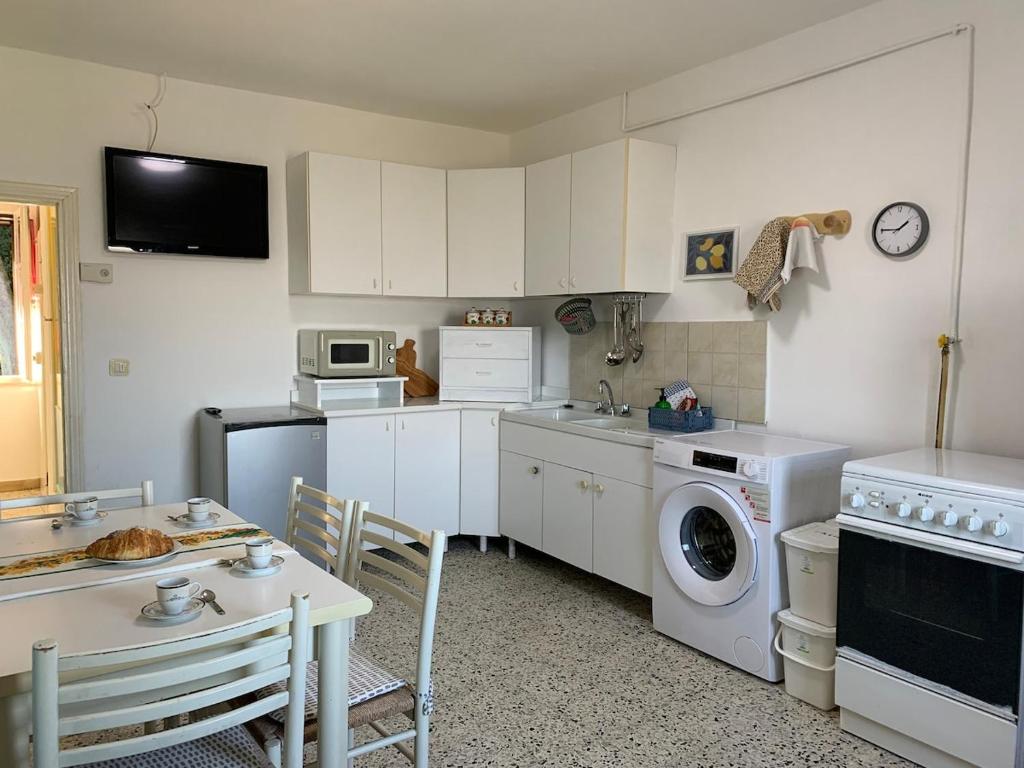 uma cozinha com armários brancos e uma máquina de lavar e secar em Grazioso Appartamento in Centro con Vista em Todi