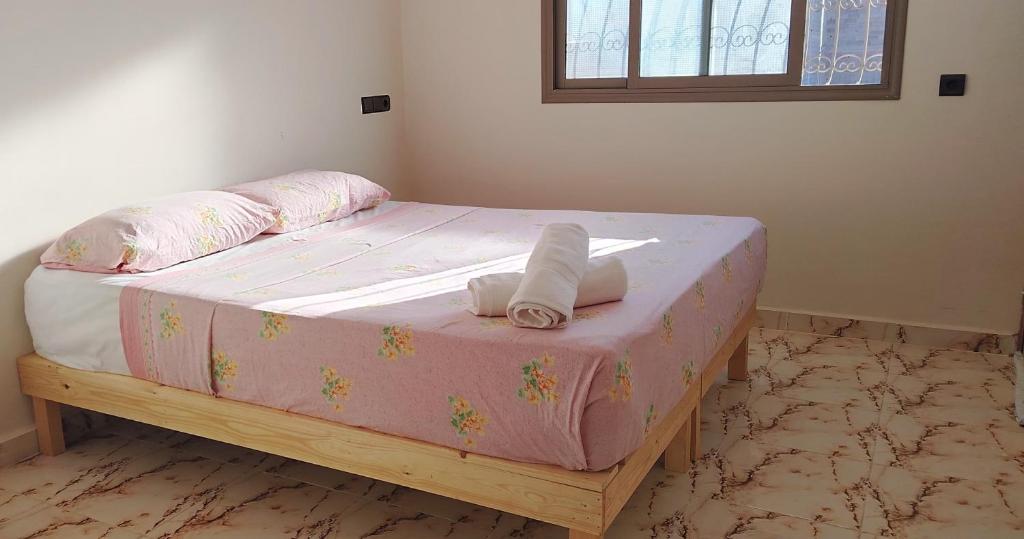 ein Schlafzimmer mit einem rosa Bett mit Handtüchern darauf in der Unterkunft Dar Fatima in Aït Ali