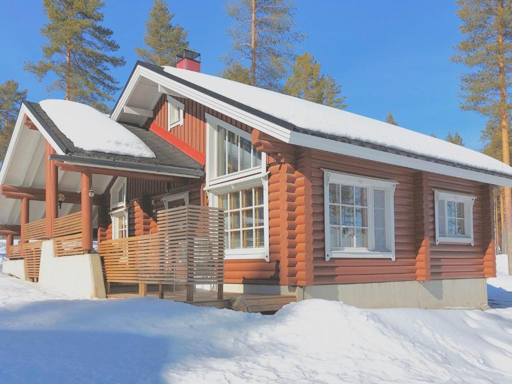 ein Holzhaus mit Schnee auf dem Dach in der Unterkunft Holiday Home Honkakoli 1 in Kolinkylä