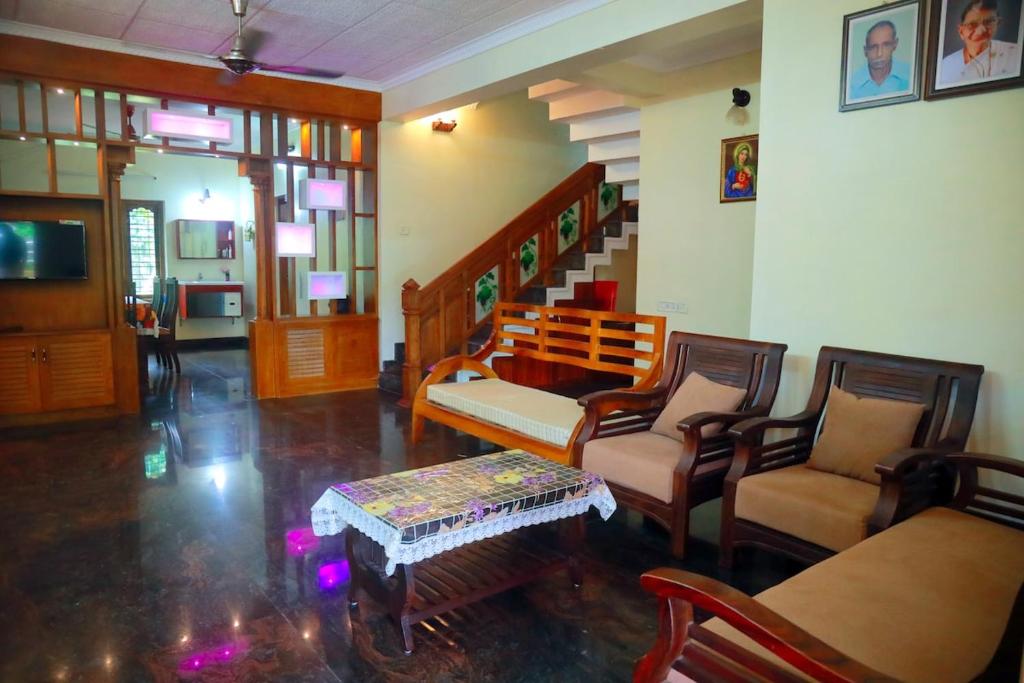 un salon avec des chaises, un canapé et une table dans l'établissement Home Near Sabarimala, à Rānī