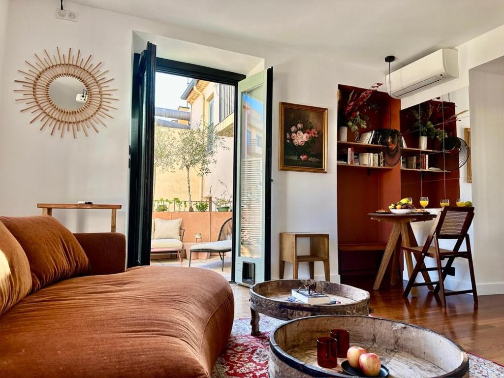 a living room with a couch and a table at L'âme de Nice - Terrasse dorée sur Place Masséna in Nice