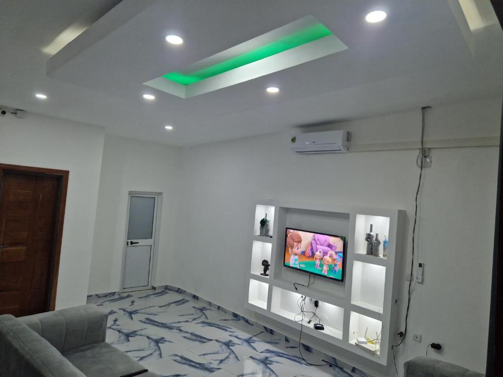 a living room with a tv on a white wall at Família Augusto in Luanda