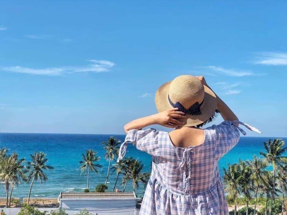 a woman in a hat standing on the beach at Khách Sạn - Homestay QUANG VINH Đảo Lý Sơn in Ly Son