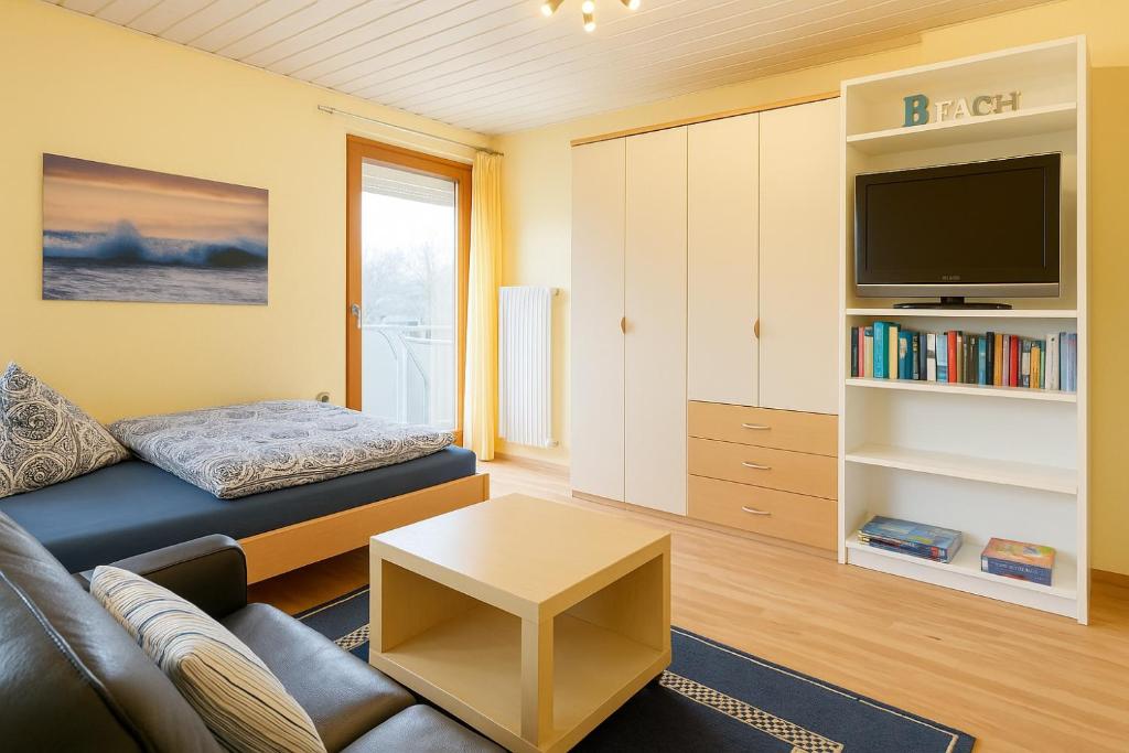 a living room with a couch and a tv at Fewo Birnau in Unteruhldingen