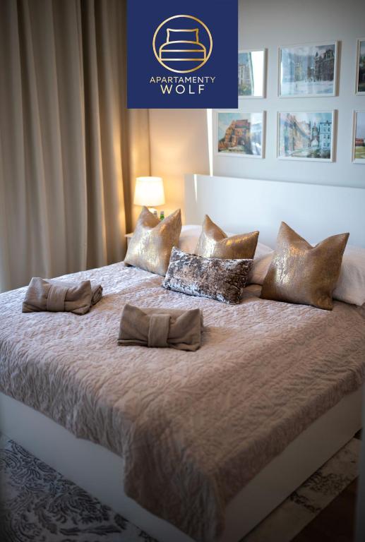 a large bed with gold pillows on top of it at Apartament Kaszmirowy in Grudziądz