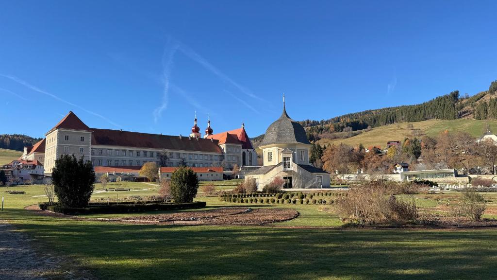ein großes Gebäude auf einer grünen Wiese in der Unterkunft Das Steirer-Nest in Sankt Lambrecht
