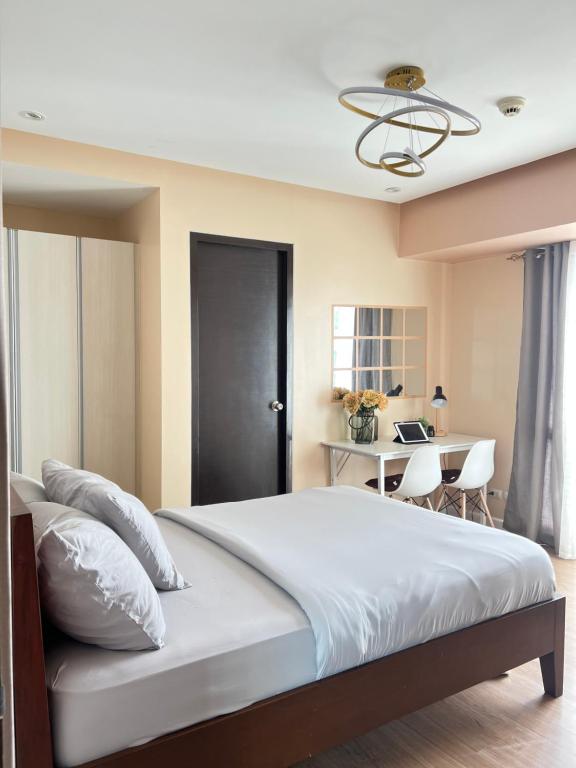 a bedroom with a large bed and a desk at Abreeza Tower 1 in Davao City