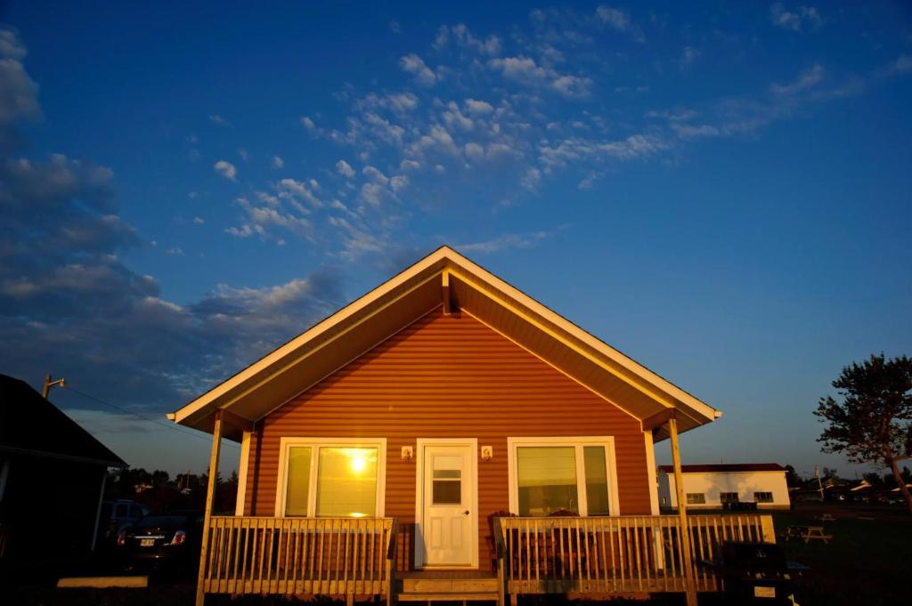 a small house with chairs in front of it at Chalets l'Acadien sur mer in Petit Rocher