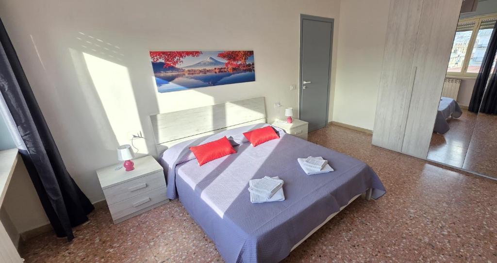 a bedroom with a blue bed with red pillows at Home Lazio 36 in Cosenza