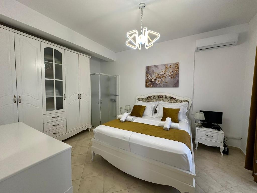 ein Schlafzimmer mit einem großen Bett und einem Kronleuchter in der Unterkunft Vila Dy Bukurite in Draç