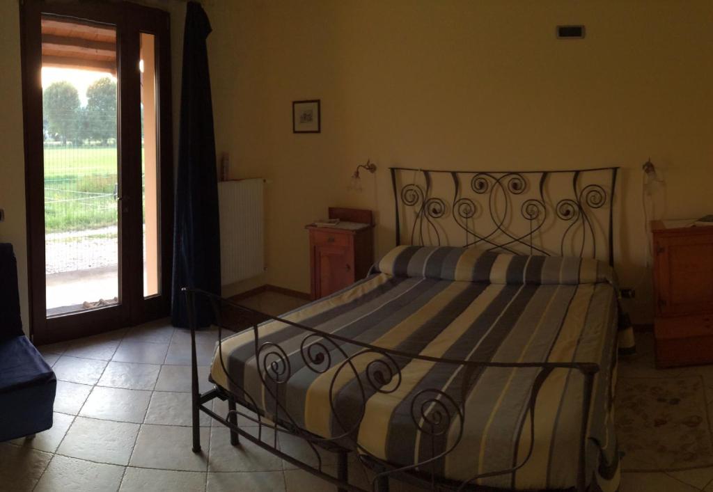 um quarto com uma cama e vista para um campo em Agriturismo San Floreano em Buia