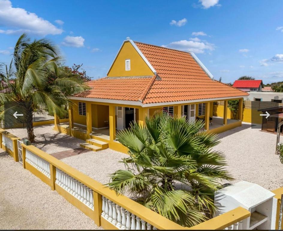 a yellow house with an orange roof at villa suiker tuintje in Kralendijk
