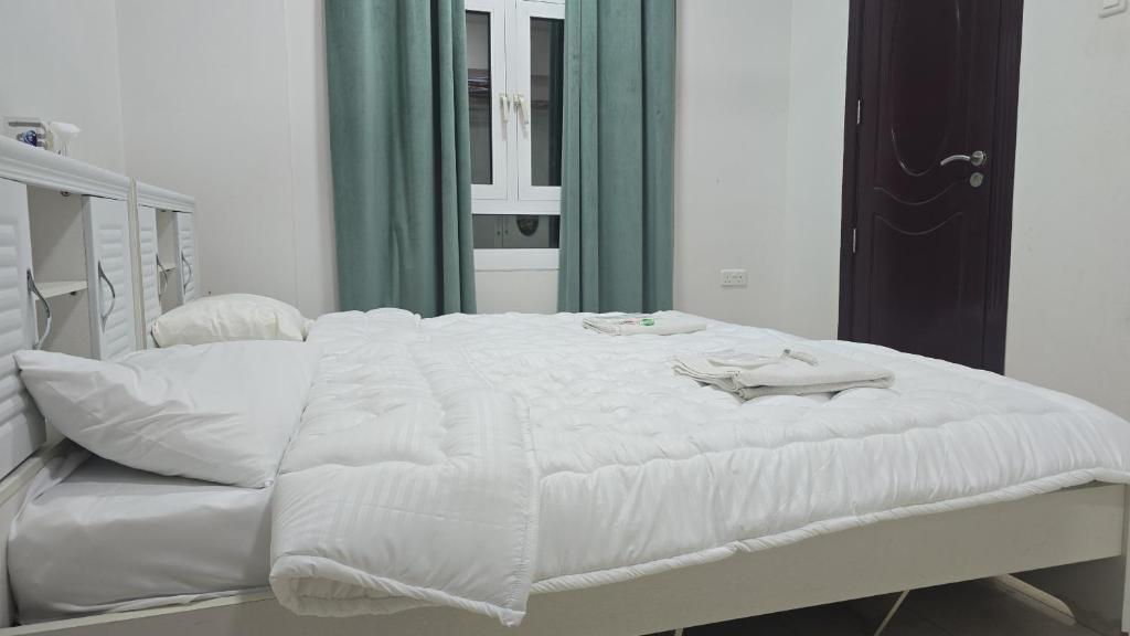 a white bed in a room with a mirror at شقة جميلة مطلة على الشاطيLuxury MUSCAT Apartment with Sea View in Ḩayl Āl ‘Umayr
