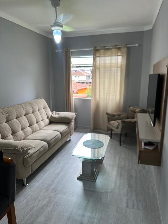 a living room with a couch and a table at Apartamento canto do forte in Praia Grande
