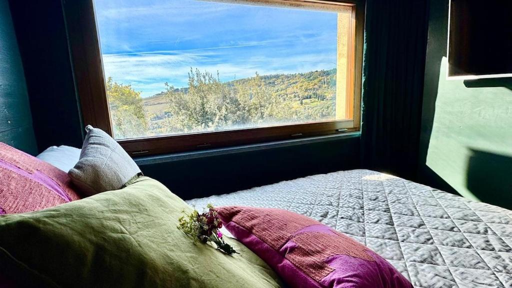 una cama en una habitación con una ventana grande en ASTOR - La Dolce Vita the Tuscan way, en Montecatini Val di Cecina