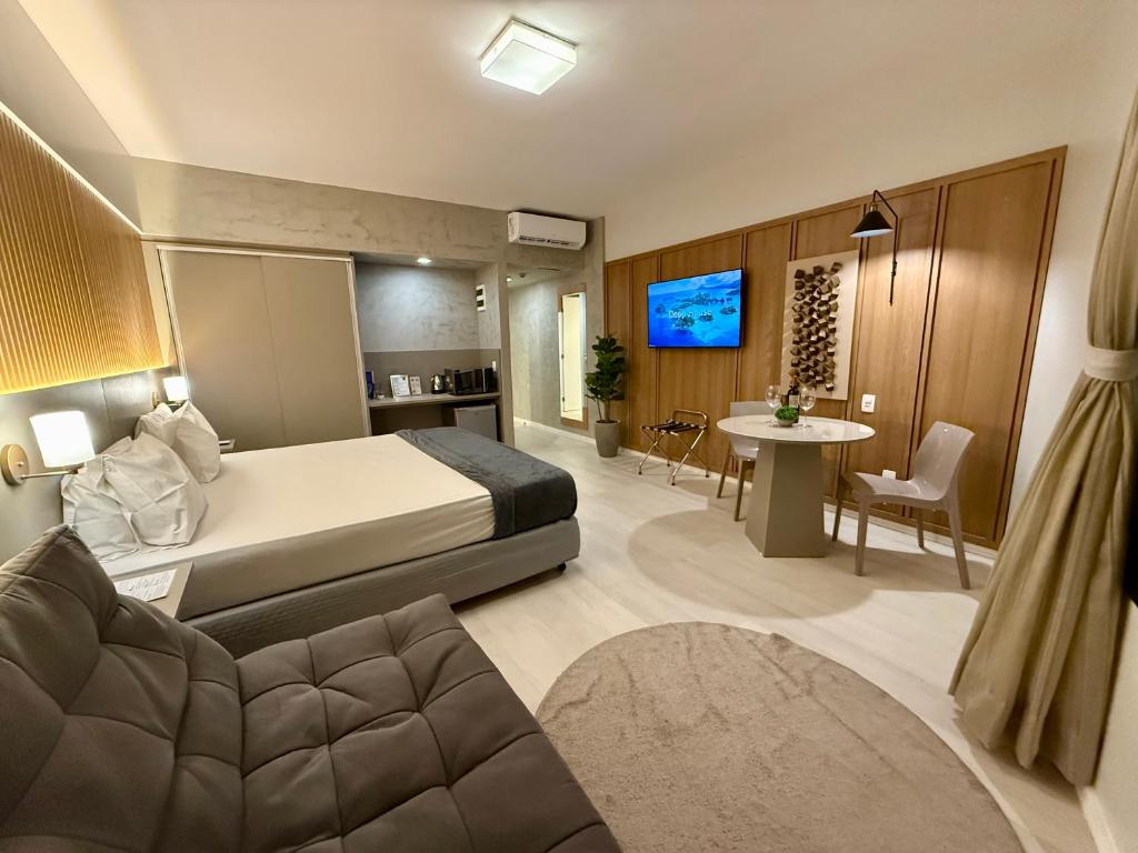Una habitación de hotel con una cama y una sala de estar. en Hotel Bourbon - Quarto 1603 - Beira Mar de Fortaleza - Vista Mar, en Fortaleza