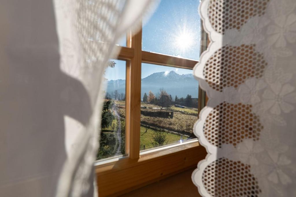 a bedroom window with a view of a mountain at Willa Szept Giewontu-Mountain Base in Kościelisko