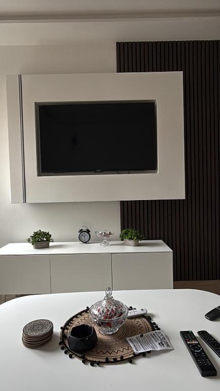 einen weißen Tisch mit einem TV an der Wand in der Unterkunft Stan Sarajevo in Sarajevo