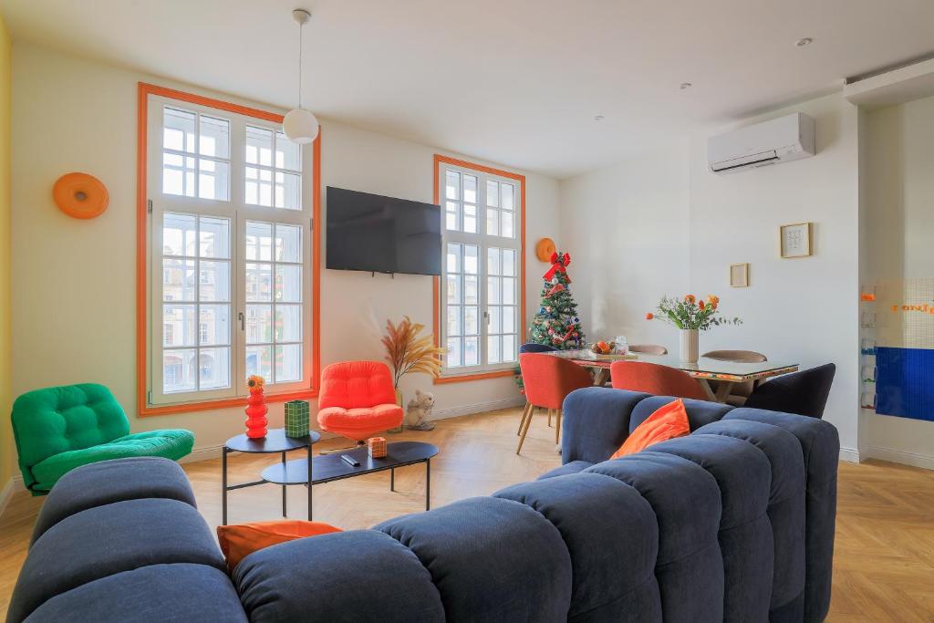 a living room with a blue couch and colorful chairs at Duplex coloré 6 personnes Place des Héros - vue Beffroi - Centre ville in Arras