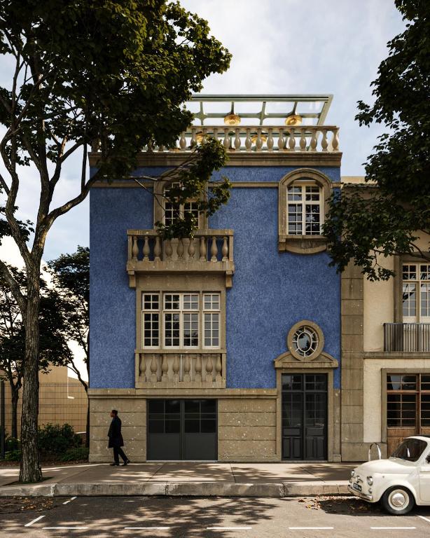 a man walking in front of a blue building at Roma Nueve Dos Hotel Boutique in Mexico City