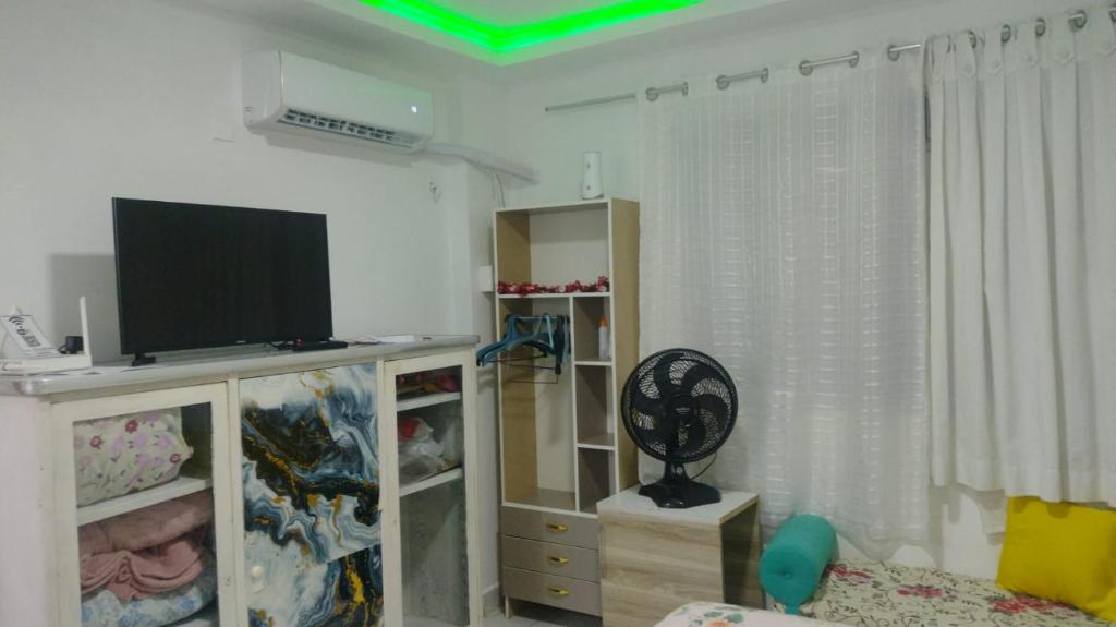 a living room with a flat screen tv on a entertainment center at Suíte com a melhor vista de Manaus in Manaus