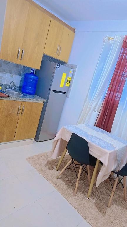 a small kitchen with a table and a refrigerator at Rosanna in Santiago de los Caballeros