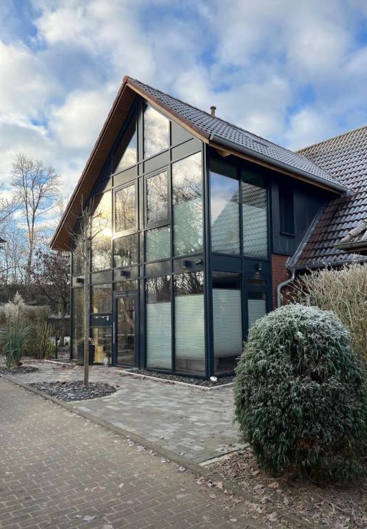 a house with large glass windows on the side of it at Gemütliche Heidschnucke in Soltau