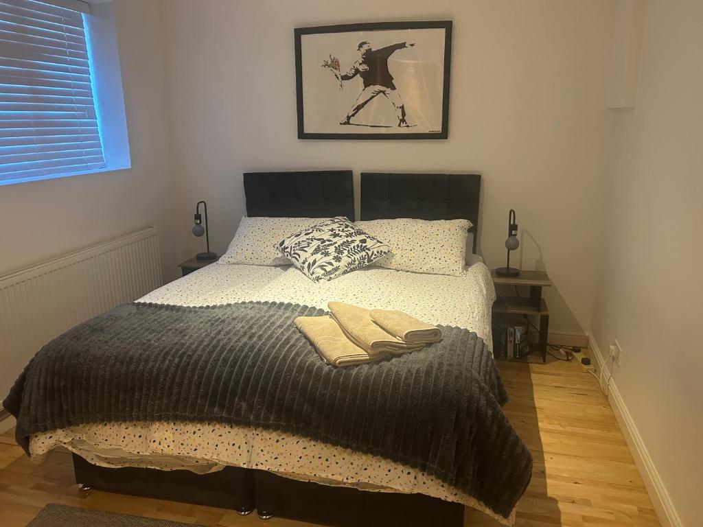 a bedroom with a bed with two towels on it at Cozy 1 Bedroom Basement Flat in London