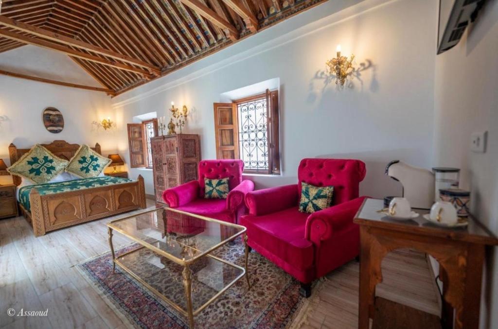 a living room with two red chairs and a table at Dar Chama in Chefchaouene