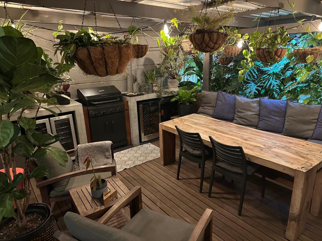 un soggiorno con un tavolo e alcune piante di Green Oasis in Blouberg Hot Tub Kids Paradise a Città del Capo