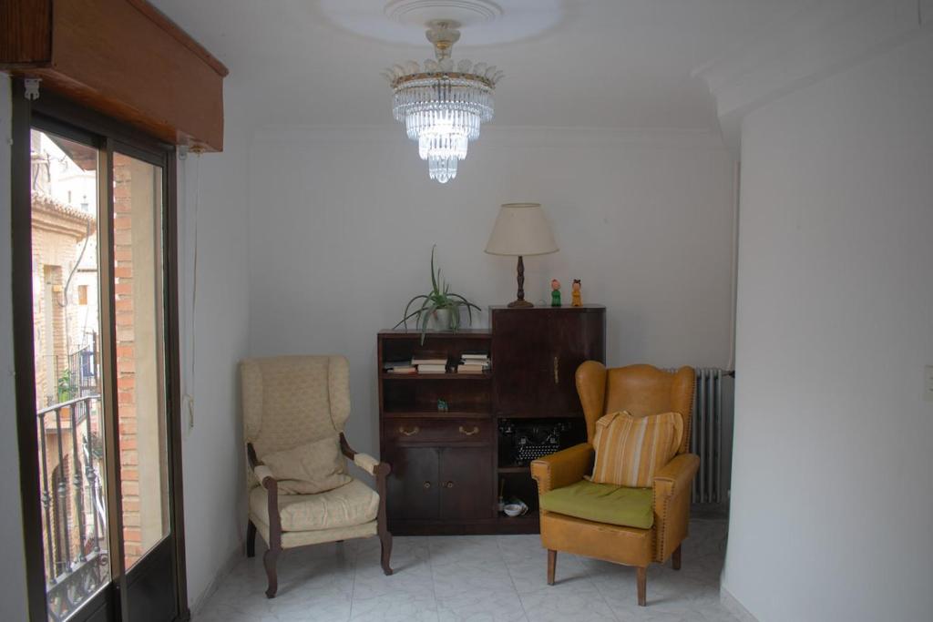a room with two chairs and a desk and a chandelier at Toledo Downtown - Apartment for 6 in Toledo