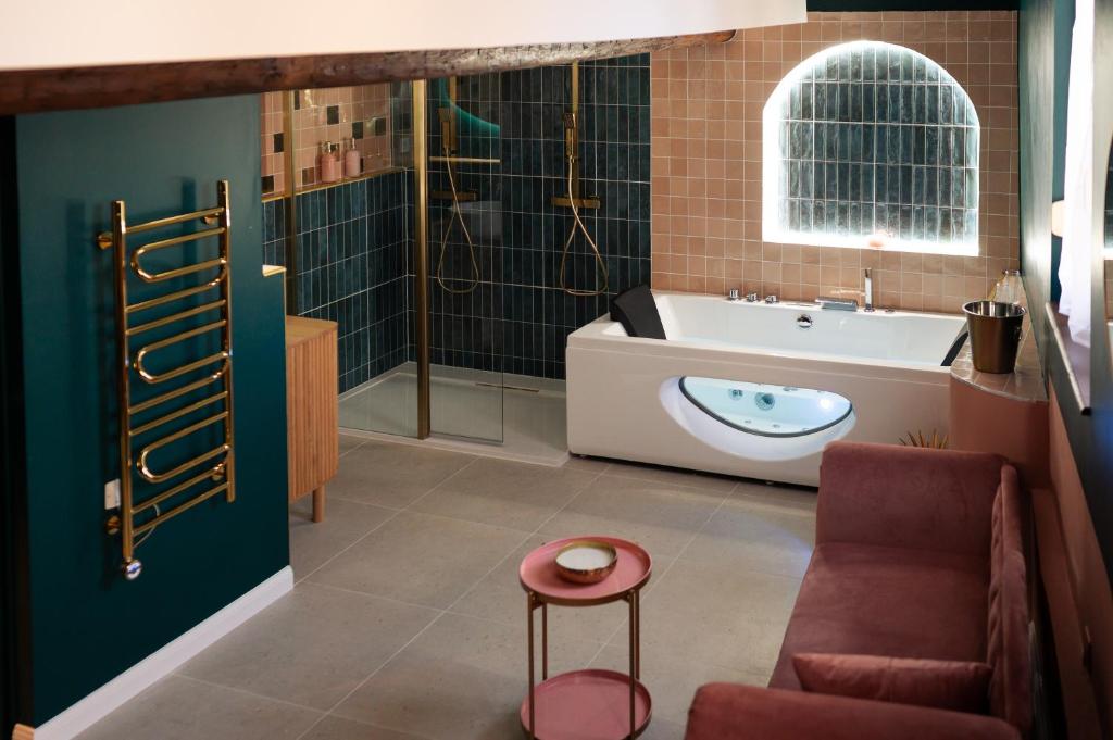 ein Badezimmer mit Badewanne, Toilette und Waschbecken in der Unterkunft l'écrin du désir in Capestang