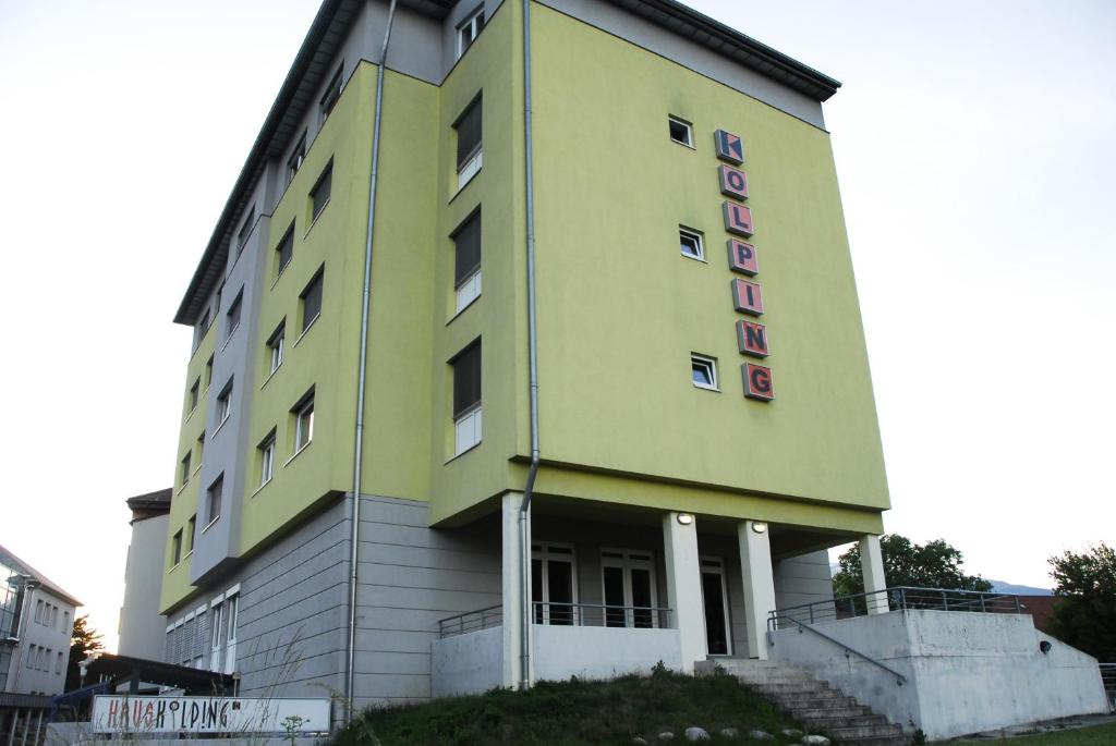un edificio amarillo con un cartel en el costado en Kolpinghaus Spittal, en Spittal an der Drau