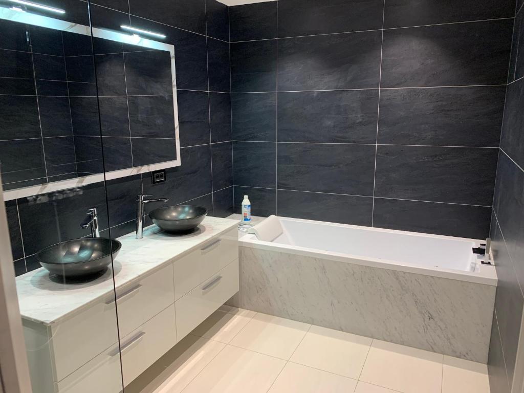 a bathroom with two sinks and a bath tub at Ourthe Basse in La Roche-en-Ardenne