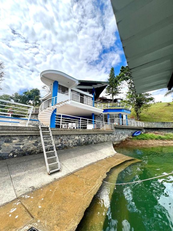 Chalet Lago Calima - Piscina Natural y Jacuzzi في كاليما: منزل به سلم بجوار نهر