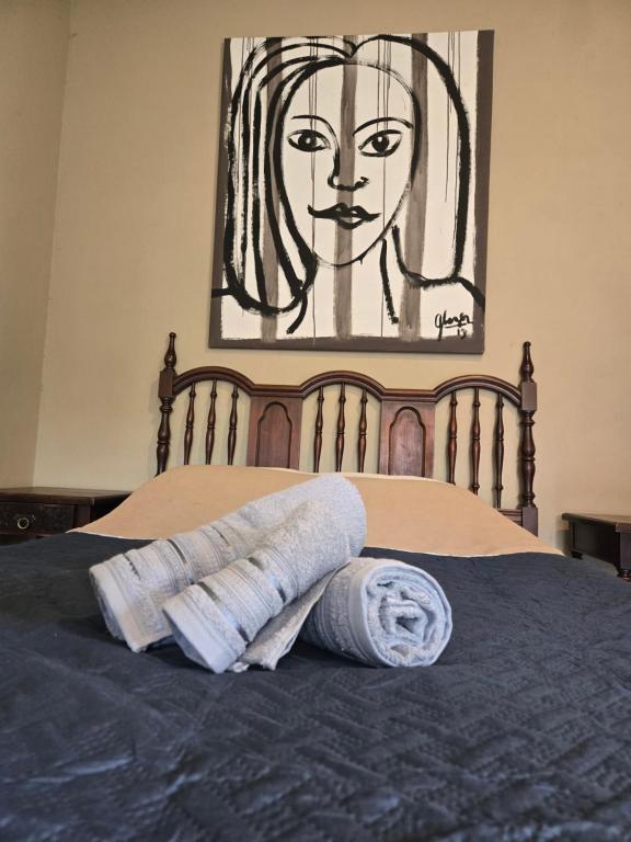 una pila de toallas en una cama con una pintura en La Tata, en Veronica