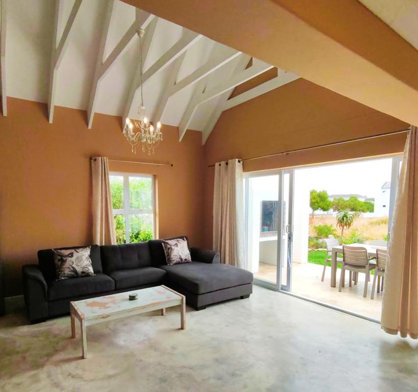 The Fifth Tee Villa في Stompneusbaai: غرفة معيشة مع أريكة وطاولة