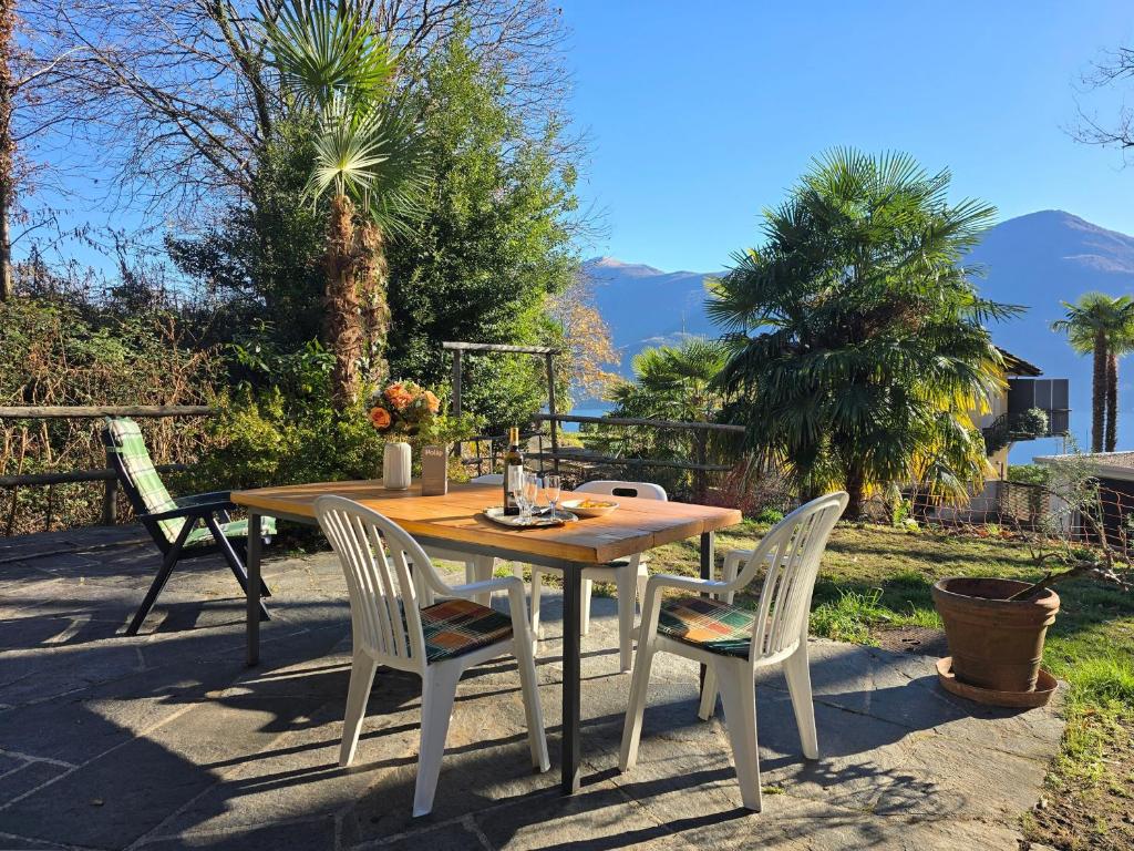 a wooden table and chairs on a patio at Rustico Kevin by HolAp SA in Brissago