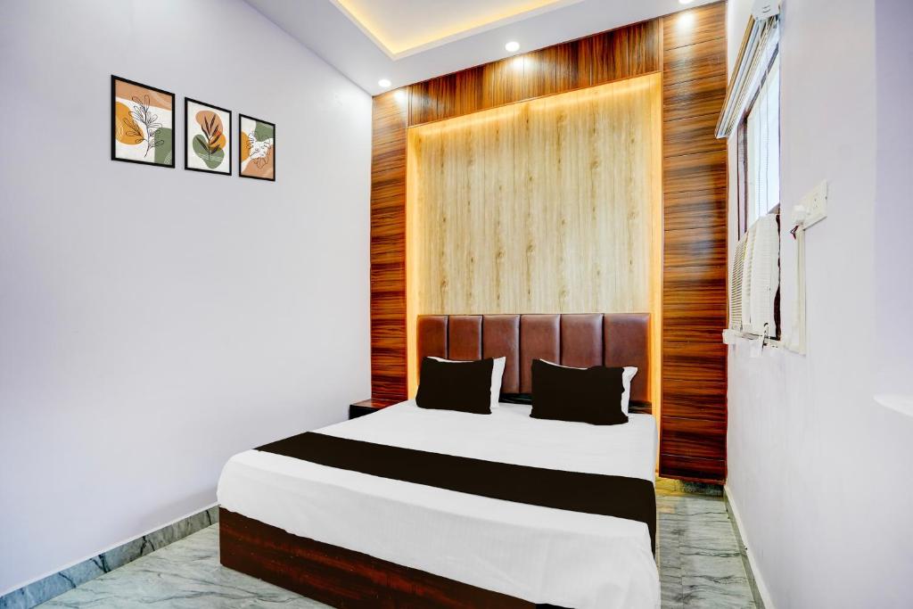 una camera da letto con un letto e una parete di legno di HOTEL O JANKI Kalyanpur Railway Station a Kānpur