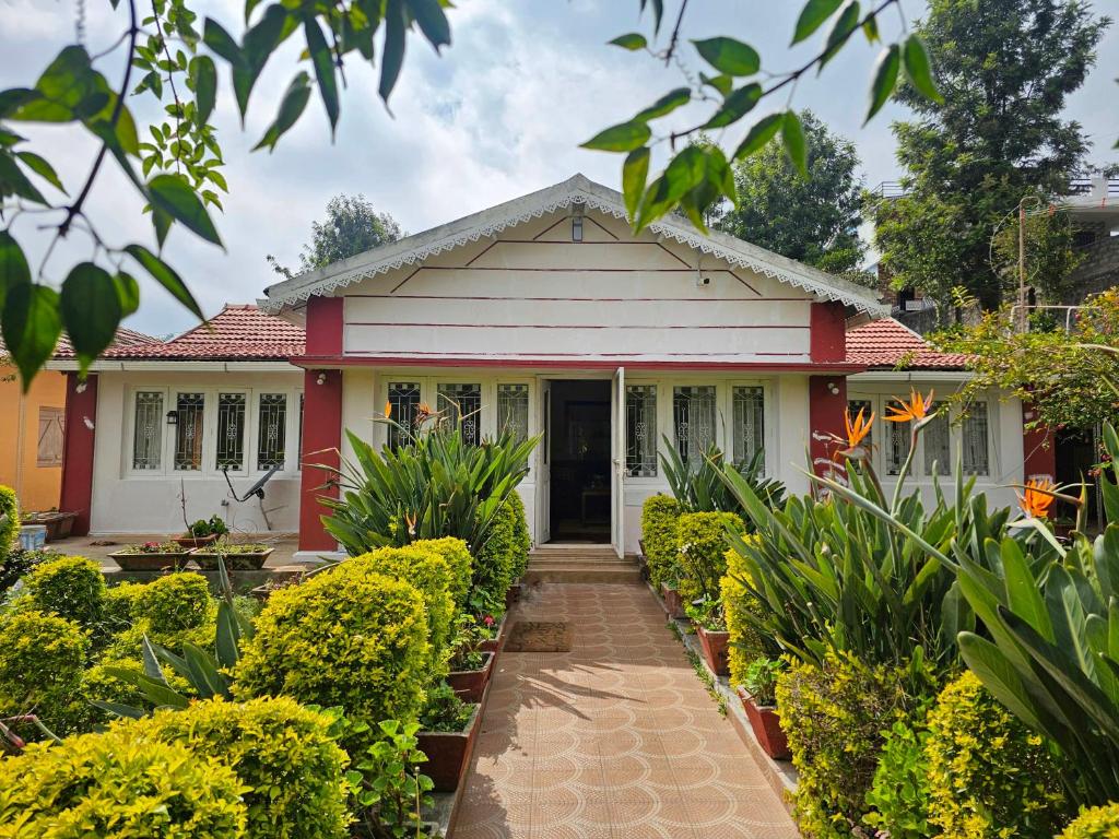 ein Zuhause mit einem rot-weißen Haus in der Unterkunft The Cottage Coonoor AS in Coonoor