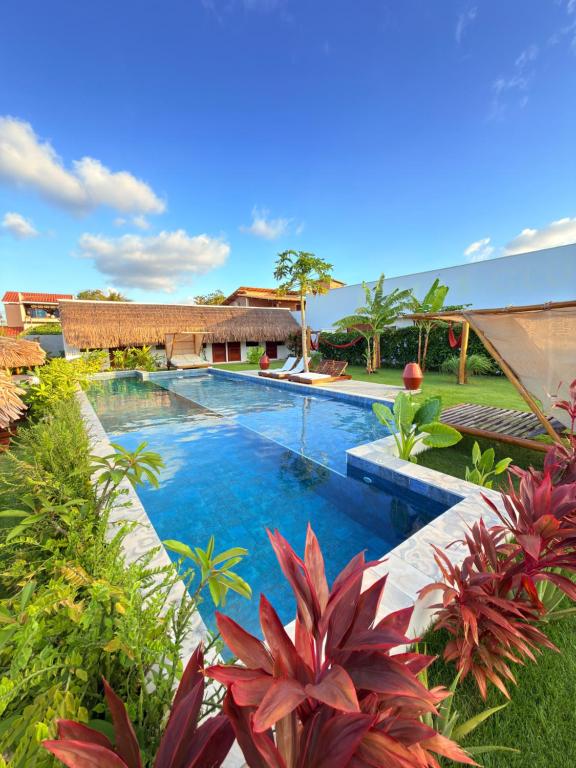 een zwembad in een tuin met planten bij CACTUS CLUB - Hotel, Wellness Center & Spa in São Miguel do Gostoso