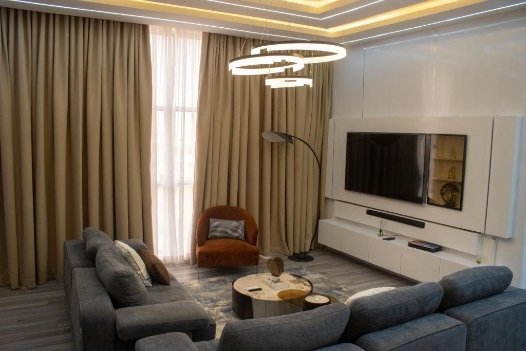 Una sala de estar con un sofá y un televisor. en B'gatti Apartments, en Lagos