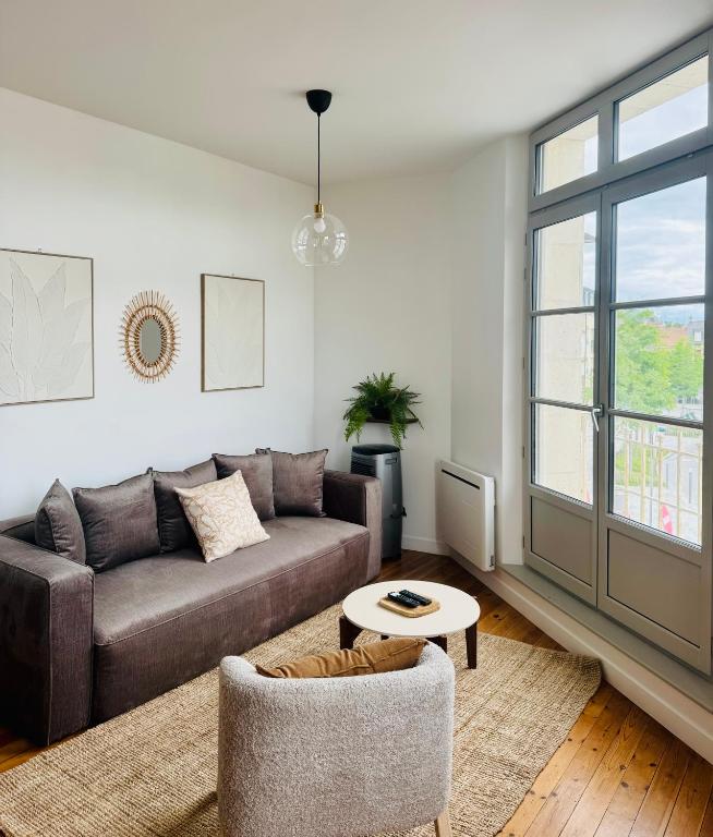 a living room with a couch and a table at Côté Aisne - vue imprenable in Soissons