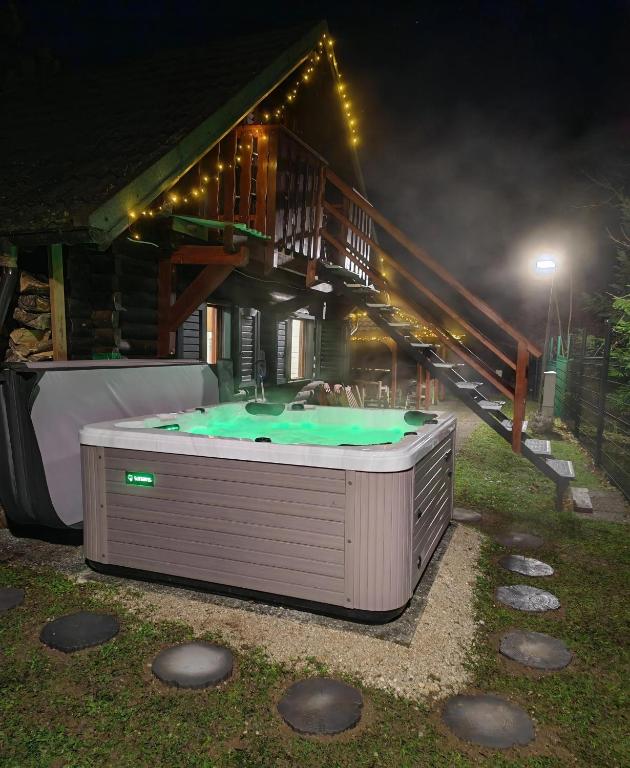 a hot tub in front of a house at night at WoodHouseDream Jakuzzi in Nazarje