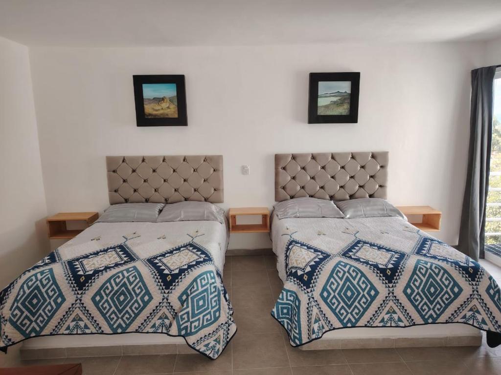 due letti uno accanto all'altro in una camera da letto di Mini Hotel El Mezquite a Villa Doctor Mora