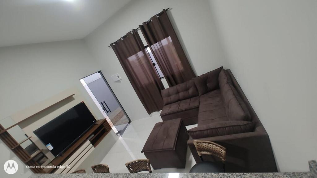 a living room with a couch and a television at Casa Proxima do Centro in Primavera do Leste