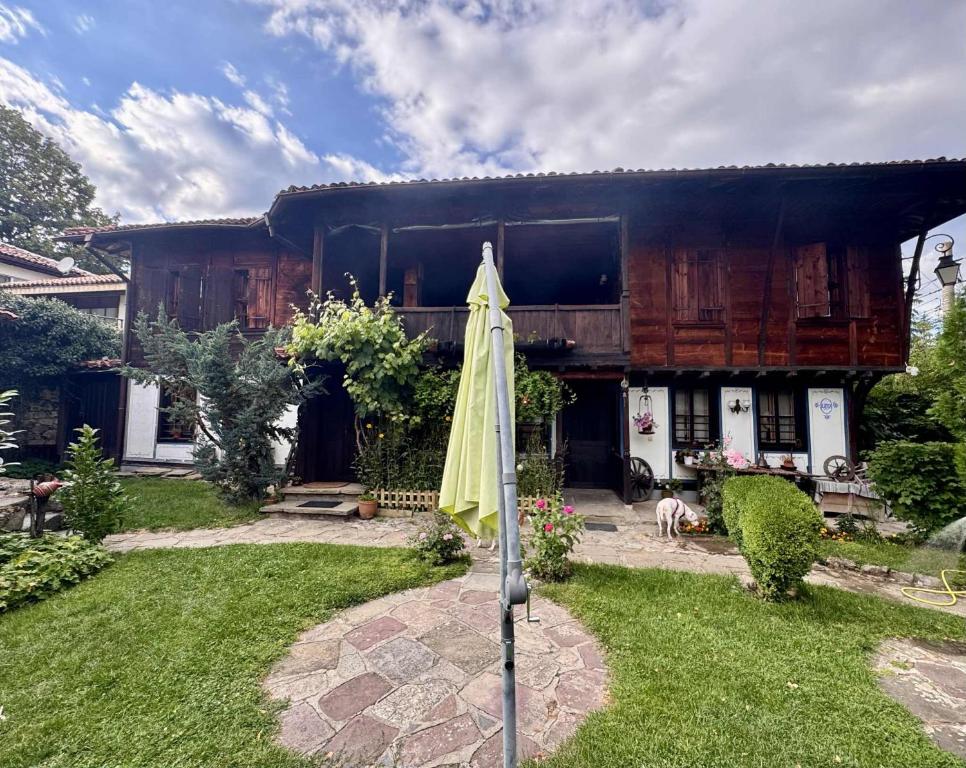 een paraplu in de tuin van een huis bij Мандулова Къща in Koprivshtitsa