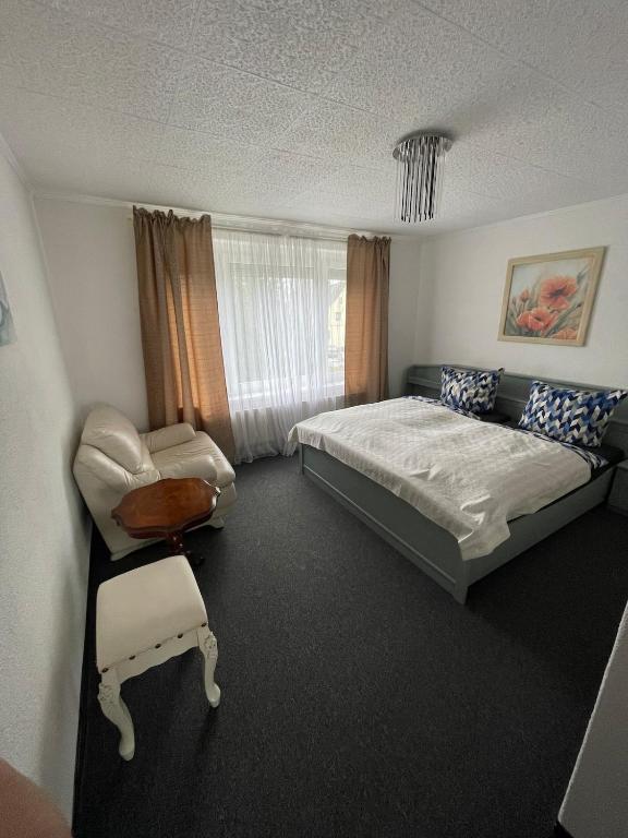 a bedroom with a bed and a chair at Nussknackerstube in Seiffen