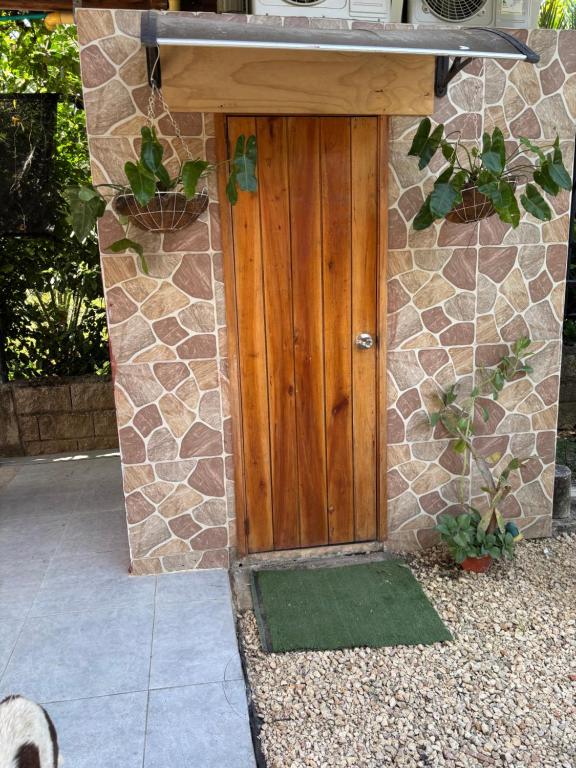 una puerta de madera de una casa con una pared de piedra en Casa finca platanales, en Cartagena de Indias